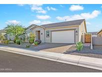 Tan house with desert landscaping and a two-car garage at 17917 W Amberwood Dr, Goodyear, AZ 85338