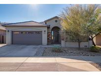 Modern home's exterior features a two-car garage and stone accents at 23852 N 167Th Ln, Surprise, AZ 85387