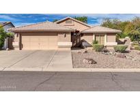 Single-story home with a two-car garage and landscaped front yard at 16128 W Monte Cristo Ave, Surprise, AZ 85374