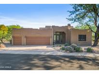 Stunning stucco home with a three-car garage and desert landscaping at 27901 N Tranquilo Ln, Rio Verde, AZ 85263