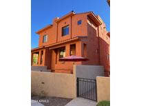 Orange two-story home with a gated entrance and walkway at 9551 E Redfield Rd # 1024, Scottsdale, AZ 85260