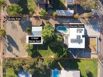 Aerial view showing house, pool, 5-stall horse barn and owned solar panels at 4331 W Port Au Prince Ln, Glendale, AZ 85306