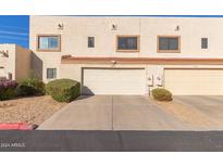 Tan two-story townhome with attached garage and landscaping at 4838 W New World Dr, Glendale, AZ 85302