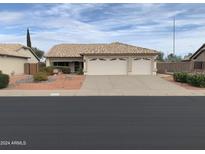 Three-car garage and desert landscaping at 20407 N 107Th Dr, Sun City, AZ 85373