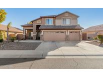 Two-story house with three-car garage and desert landscaping at 7827 W Donald Dr, Peoria, AZ 85383