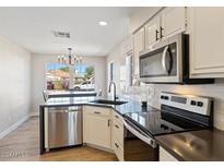 Modern kitchen features stainless steel appliances and updated cabinetry at 6617 E Northridge St, Mesa, AZ 85215