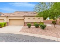 Tan stucco house with a tile roof and landscaping at 1404 N Desert Willow St, Casa Grande, AZ 85122