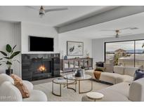 Bright living room with a fireplace, large windows, and comfortable seating at 3800 E Lincoln Dr # 42, Phoenix, AZ 85018