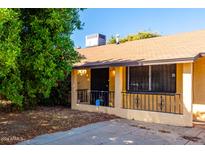 House exterior featuring a yellow single story home with a small front porch at 7340 W Glenrosa Ave, Phoenix, AZ 85033