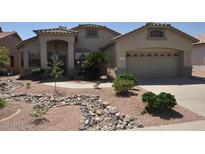Single story home with two-car garage and rock landscaping at 18071 W Douglas Way, Surprise, AZ 85374