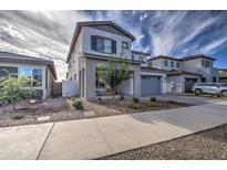 Two-story home with modern gray exterior and landscaped front yard at 22569 E Saddle Way, Queen Creek, AZ 85142