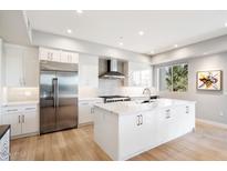 Modern kitchen with white cabinets, large island, and stainless steel appliances at 16580 N 92Nd St # 2001, Scottsdale, AZ 85260