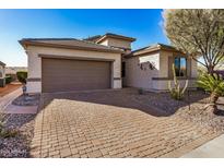 Single-story home with a two-car garage and a brick paved driveway at 18478 N Canal Dr, Surprise, AZ 85374