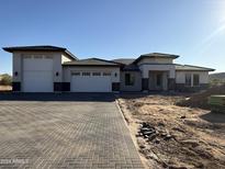 New construction home with a three-car garage and brick driveway at 3295 W Mesquite St, Phoenix, AZ 85086