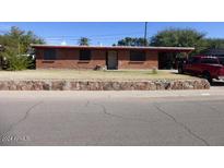 Brick ranch home with a landscaped yard and rock wall at 416 W Greenwich Rd, Kearny, AZ 85137