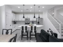 Modern kitchen with white cabinets, island, and black and white accents at 4636 E Tierra Buena Ln, Phoenix, AZ 85032