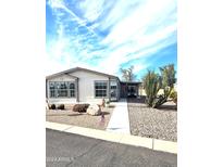 Tan colored manufactured home with carport and walkway at 2400 E Baseline Ave # 73, Apache Junction, AZ 85119