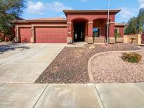 Beautiful home exterior with a two-car garage and well-manicured landscaping at 15818 W Mercer Ln, Surprise, AZ 85379