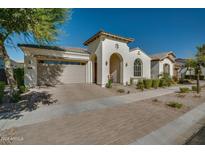 Single-story home with arched entryway, neutral color scheme, and landscaped front yard at 10124 E Cintron Dr, Mesa, AZ 85212