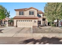 Two-story house with tan exterior, tile roof, and a two-car garage at 6782 W Firebird Dr, Glendale, AZ 85308