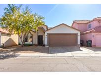 Single-story home with brown garage door and landscaping at 8323 W Alvarado St, Phoenix, AZ 85037