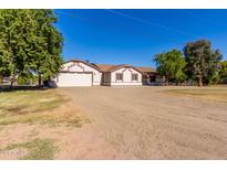 Ranch-style home with a large driveway and mature trees at 19208 E Appleby Rd, Queen Creek, AZ 85142