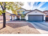 Two-story house with gray garage door and desert landscaping at 10847 E Forge Cir, Mesa, AZ 85208