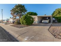 Single-wide manufactured home with carport and landscaped front yard at 5546 E Player Pl, Mesa, AZ 85215