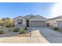 One-story home with gray siding, two-car garage, and desert landscaping at 23407 W Winslow Ave, Buckeye, AZ 85326