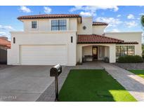Two-story home with a white exterior, red tile roof, and artificial turf at 16008 N 56Th Way, Scottsdale, AZ 85254