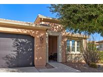 Tan one-story house with dark brown garage door and landscaping at 856 E Harmony Way, San Tan Valley, AZ 85140