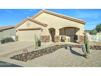 Tan house with a two-car garage, desert landscaping, and a small covered patio at 2101 S Meridian Rd # 145, Apache Junction, AZ 85120