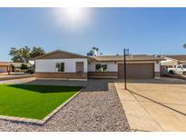 Single-story home with two-car garage and landscaped yard at 4302 N 80Th Ln, Phoenix, AZ 85033