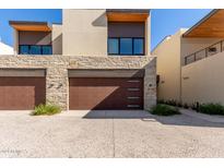 Modern home with stone and wood accents, featuring a two-car garage and landscaped grounds at 6311 E Phoenician Blvd # 18, Scottsdale, AZ 85251