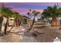 Brick pathway leads to a beautiful home surrounded by palm trees at 3507 N Snead Dr, Goodyear, AZ 85395