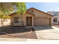 Tan house with a two-car garage and landscaping at 16019 W Moreland St, Goodyear, AZ 85338