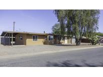 Tan single story home with carport and mature tree in front yard at 694 W Coolidge Pl, Coolidge, AZ 85128