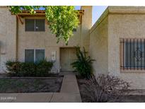 Tan two-story stucco condo building with a walkway and landscaping at 8106 N 31St Dr, Phoenix, AZ 85051