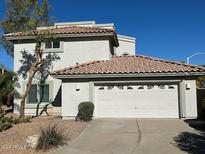 Two-story house with tile roof, attached garage, and desert landscaping at 9382 E Aster Dr, Scottsdale, AZ 85260
