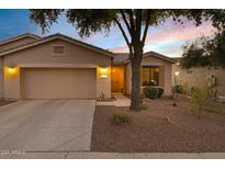 Inviting desert home exterior with a two-car garage and landscaped front yard at 20566 N Lemon Drop Dr, Maricopa, AZ 85138