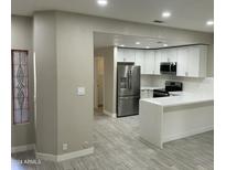 Modern kitchen with white cabinets, stainless steel appliances, and a large island at 8351 W Taro Ln, Peoria, AZ 85382