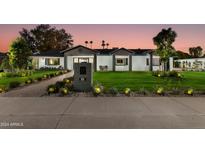Stunning curb appeal featuring a remodeled mid-century modern home with a well-manicured lawn at 8701 E Highland Ave, Scottsdale, AZ 85251
