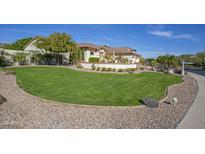 Landscaped front yard with a large grassy area and mature trees at 26702 N 97Th Ln, Peoria, AZ 85383