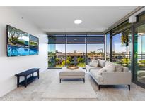Modern living room with city view, comfy sofa, and large TV at 7120 E Kierland Blvd # 416, Scottsdale, AZ 85254