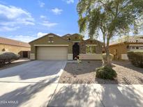 One-story house with a two-car garage and desert landscaping at 8817 W Miami St, Tolleson, AZ 85353