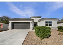 Single-story home with dark garage door and landscaped front yard at 4632 W Dill Ave, Coolidge, AZ 85128