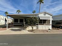 Single-wide manufactured home with carport and mature landscaping at 7750 E Broadway Rd # 149, Mesa, AZ 85208
