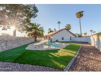 Inviting backyard oasis featuring a sparkling pool, lush landscaping, and a relaxing atmosphere at 18645 N 71St Dr, Glendale, AZ 85308