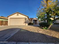 Tan house with a two-car garage and desert landscaping at 12353 N Tonya St, El Mirage, AZ 85335