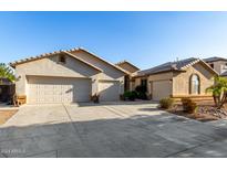 Two-story house with three-car garage and desert landscaping at 11957 N 140Th Ln, Surprise, AZ 85379